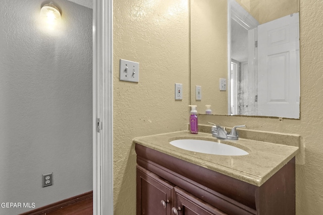 bathroom featuring a textured wall and vanity