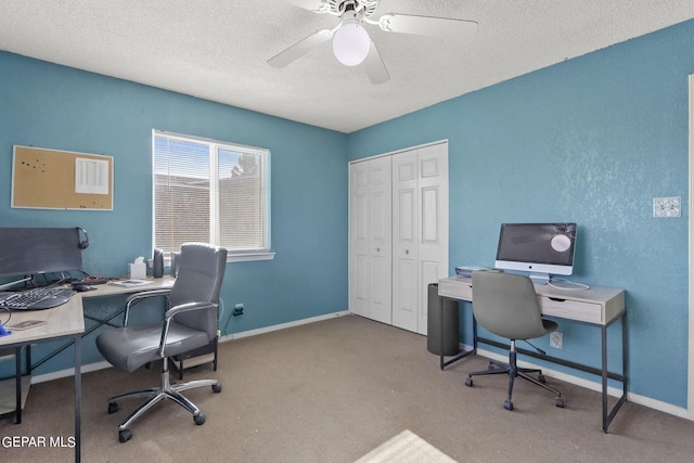 carpeted office space with ceiling fan, baseboards, and a textured ceiling