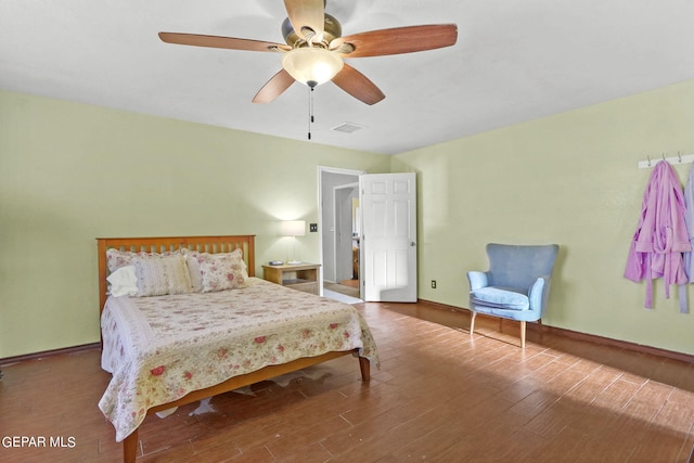 bedroom with wood finished floors, visible vents, a ceiling fan, and baseboards