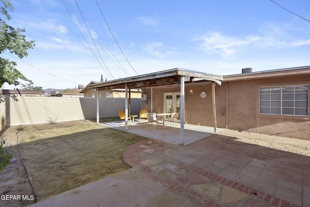 back of property featuring french doors, a patio, stucco siding, and fence