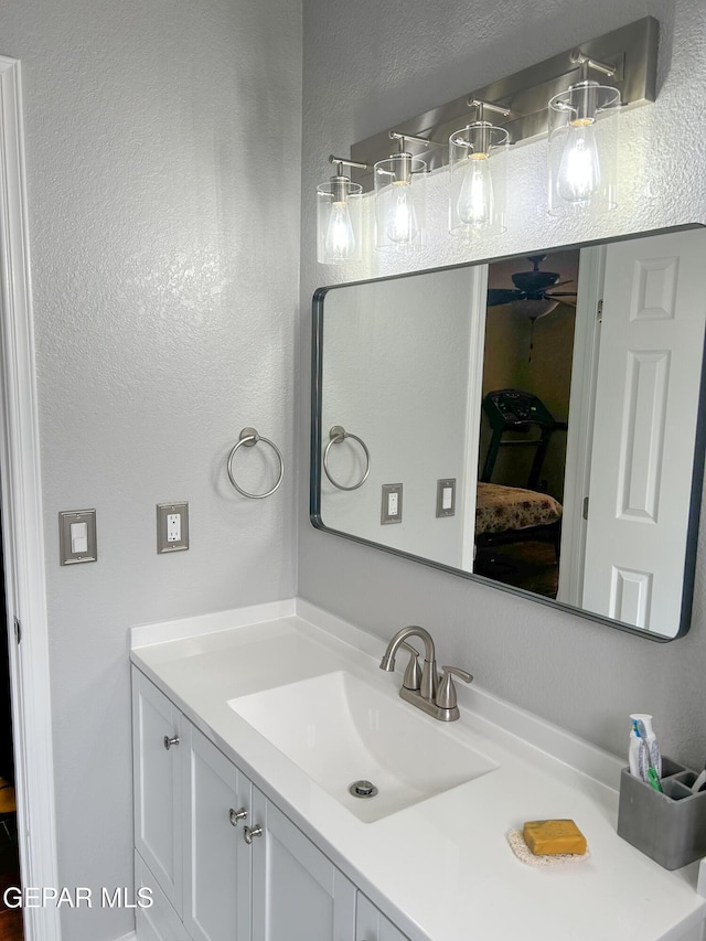 bathroom featuring a textured wall and vanity