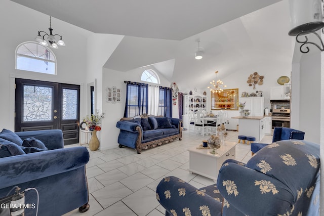 living area with a chandelier, plenty of natural light, and high vaulted ceiling