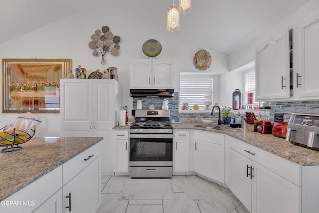 kitchen with vaulted ceiling, a sink, marble finish floor, under cabinet range hood, and gas stove