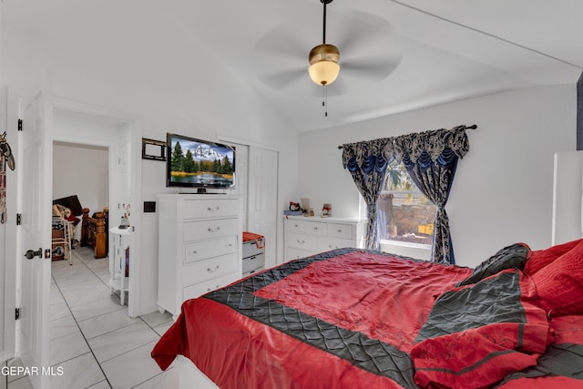 bedroom featuring vaulted ceiling, marble finish floor, a closet, and ceiling fan