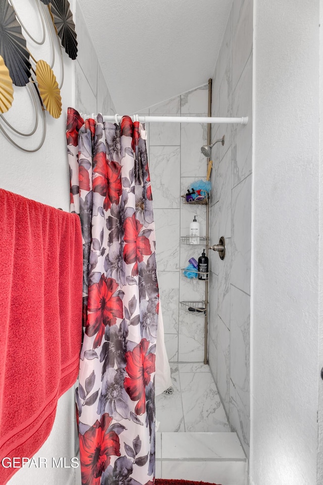 bathroom with a shower stall and marble finish floor