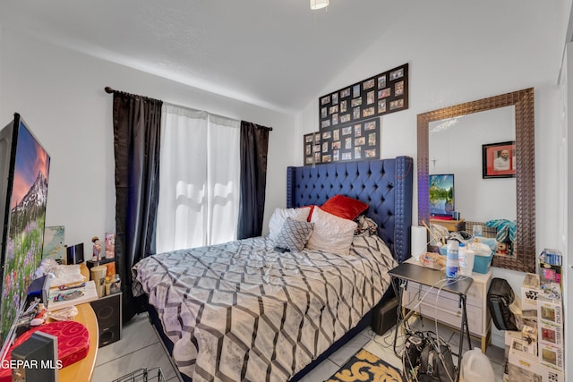bedroom with vaulted ceiling and tile patterned floors