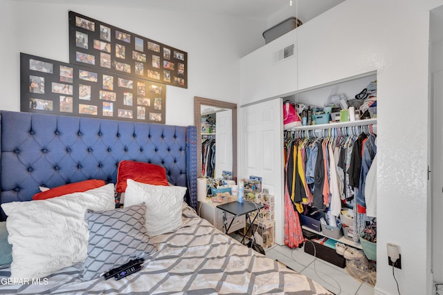 bedroom with high vaulted ceiling, visible vents, and a closet