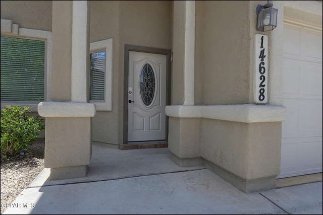 doorway to property featuring stucco siding