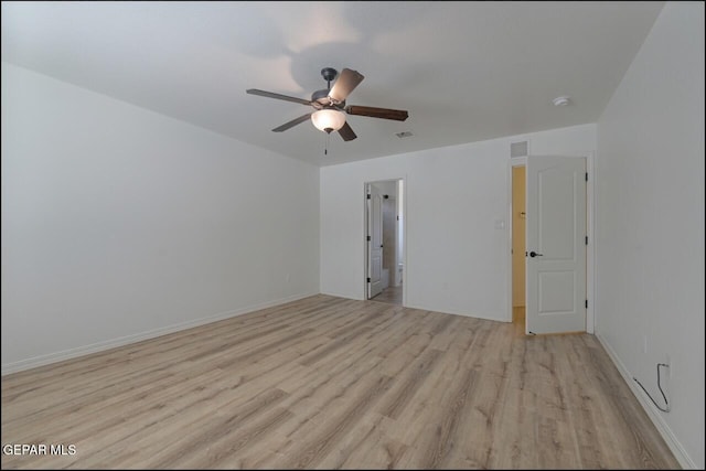 unfurnished room featuring visible vents, light wood-type flooring, a ceiling fan, and baseboards