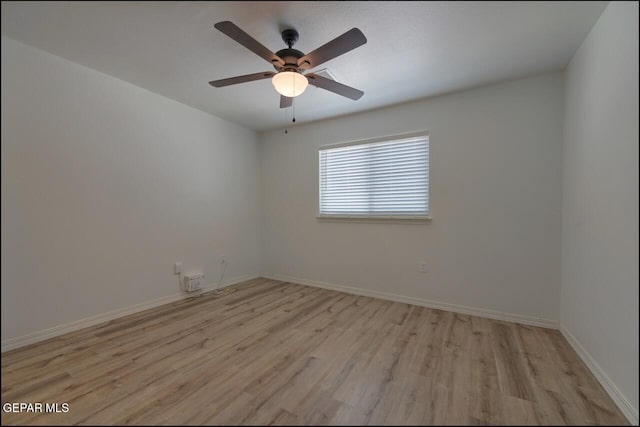 unfurnished room with a ceiling fan, baseboards, and light wood-type flooring