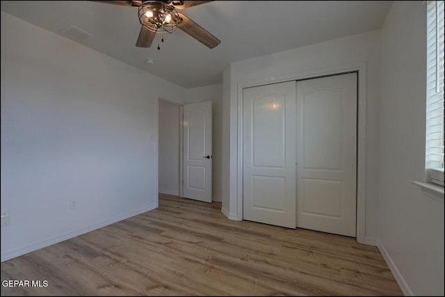 unfurnished bedroom with baseboards, visible vents, a closet, and light wood finished floors