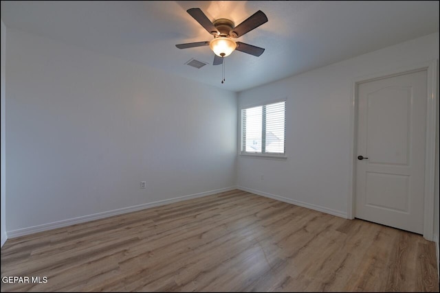 spare room featuring baseboards, visible vents, ceiling fan, and light wood finished floors