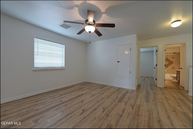 unfurnished room featuring baseboards, visible vents, light wood-type flooring, and ceiling fan