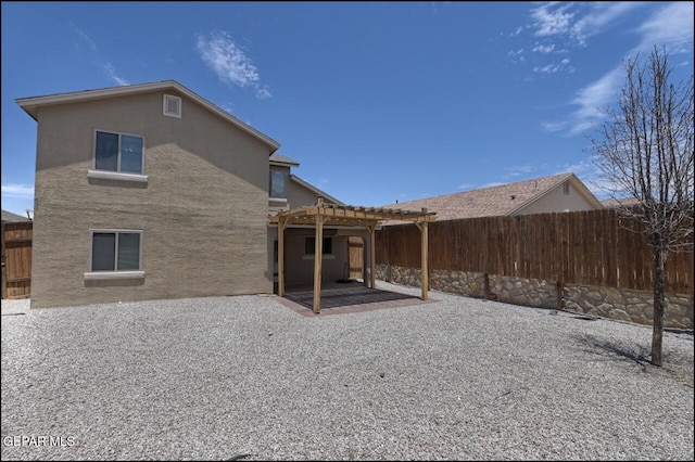 back of property featuring a pergola, a patio, stucco siding, and a fenced backyard