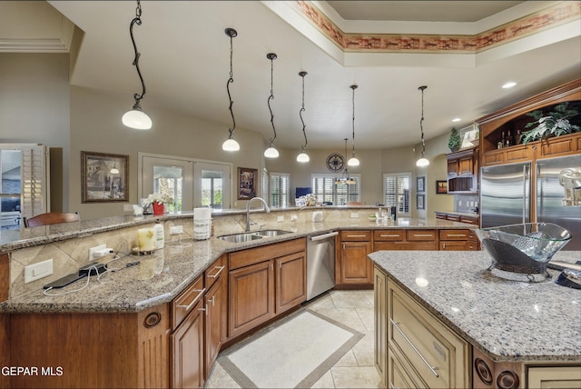 kitchen with stainless steel appliances, a large island with sink, a sink, light tile patterned flooring, and tasteful backsplash