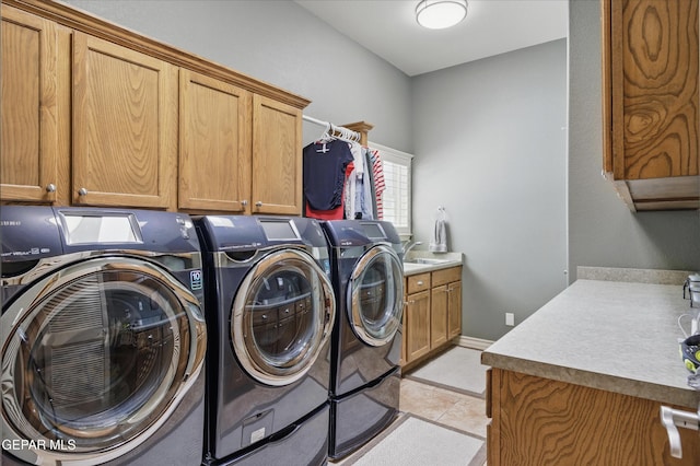 laundry room featuring cabinet space, washer and clothes dryer, and light tile patterned floors
