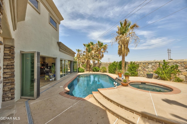 view of pool with a patio area, a fenced in pool, and an in ground hot tub