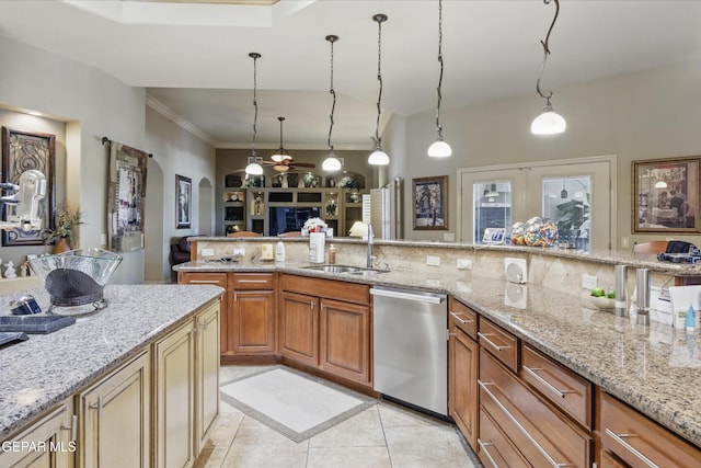 kitchen with light stone counters, stainless steel dishwasher, a sink, arched walkways, and decorative backsplash