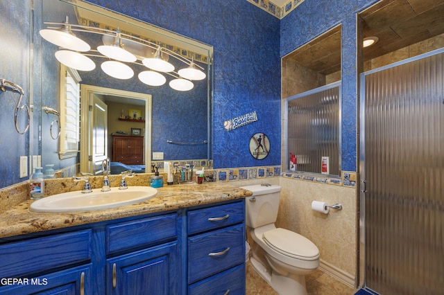 bathroom featuring wallpapered walls, an enclosed shower, toilet, and vanity