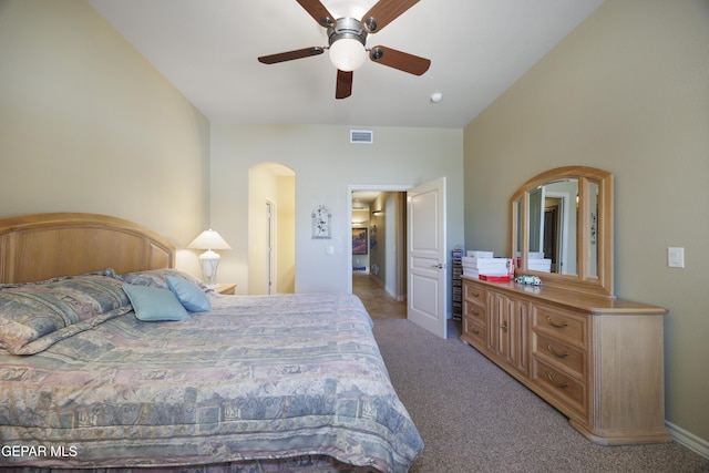 carpeted bedroom with arched walkways, a ceiling fan, visible vents, and baseboards