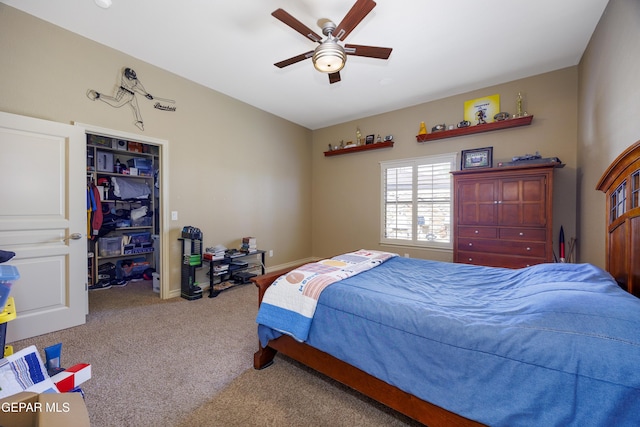 carpeted bedroom featuring a walk in closet, baseboards, a ceiling fan, and a closet
