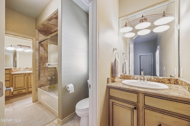 bathroom featuring enclosed tub / shower combo, tile patterned flooring, vanity, and toilet