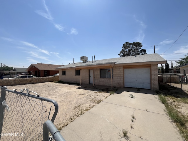 ranch-style house featuring central AC unit, concrete driveway, an attached garage, fence, and brick siding