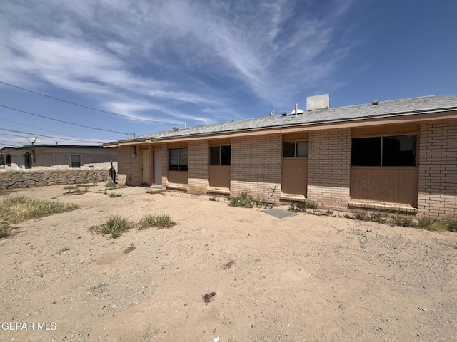 back of property featuring brick siding
