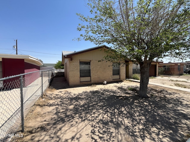 view of front of property with brick siding and fence