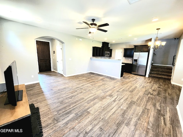 unfurnished living room with a ceiling fan, wood finished floors, arched walkways, baseboards, and recessed lighting