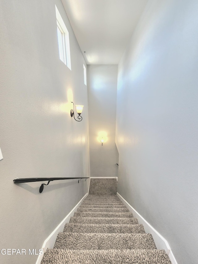 staircase featuring carpet floors and baseboards