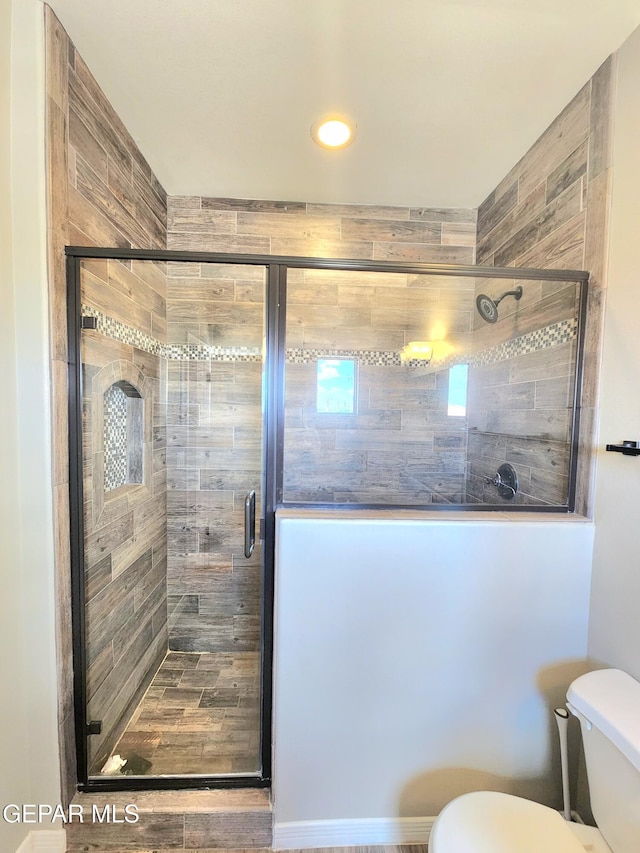 bathroom featuring toilet, a stall shower, and recessed lighting