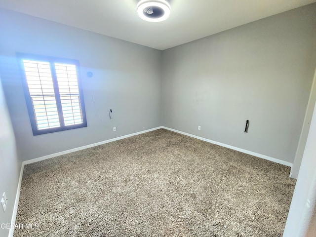 empty room featuring carpet floors and baseboards