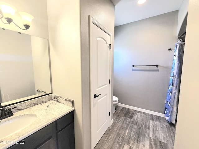 full bathroom featuring vanity, toilet, wood finished floors, recessed lighting, and baseboards
