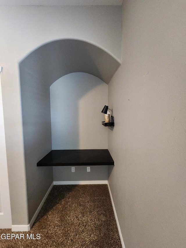 detailed view of carpet, baseboards, and arched walkways