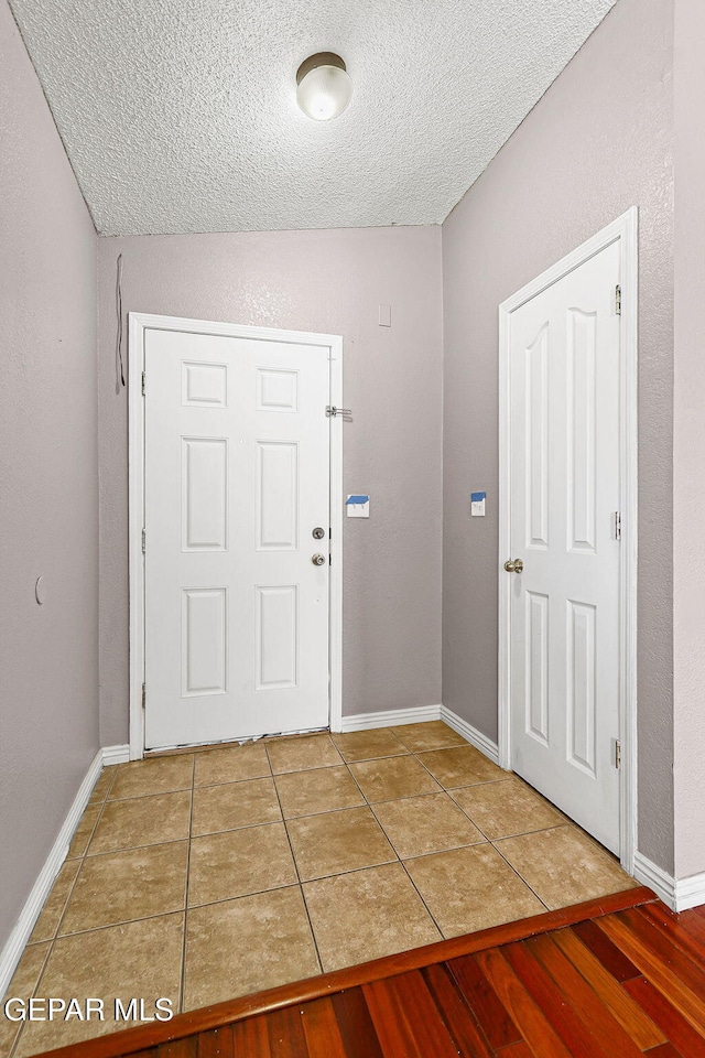 14310 Pacific Point Dr, El Paso, TX 79938 - foyer entrance with a textured ceiling, tile patterned floors, and baseboards