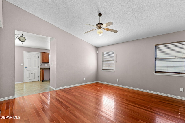 14310 Pacific Point Dr, El Paso, TX 79938 - unfurnished room with ceiling fan, a textured ceiling, light wood-style flooring, healthy amount of natural light, and vaulted ceiling