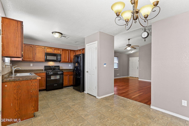 14310 Pacific Point Dr, El Paso, TX 79938 - kitchen featuring black appliances, a sink, dark countertops, baseboards, and brown cabinetry