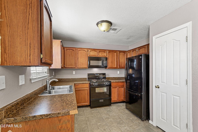 14310 Pacific Point Dr, El Paso, TX 79938 - kitchen featuring black appliances, a sink, brown cabinets, dark countertops, and a textured ceiling
