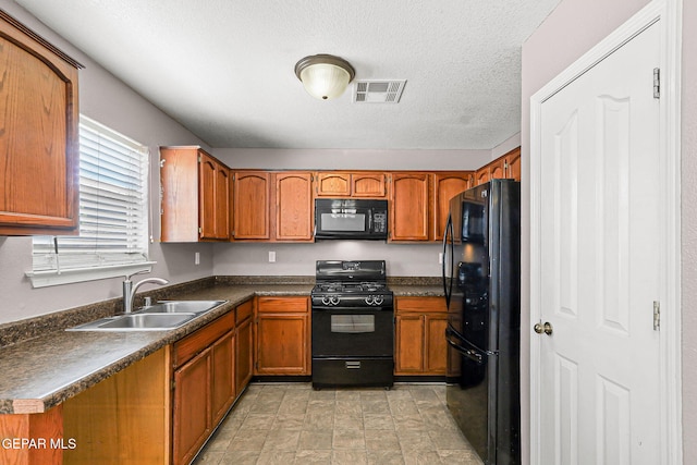 14310 Pacific Point Dr, El Paso, TX 79938 - kitchen featuring black appliances, a sink, brown cabinetry, dark countertops, and a textured ceiling