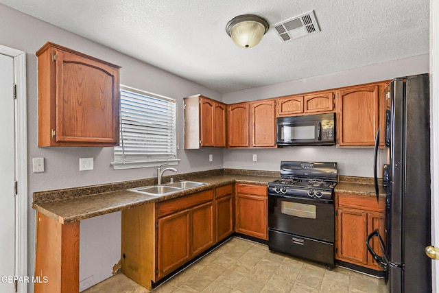 14310 Pacific Point Dr, El Paso, TX 79938 - kitchen with black appliances, a sink, dark countertops, brown cabinetry, and a textured ceiling