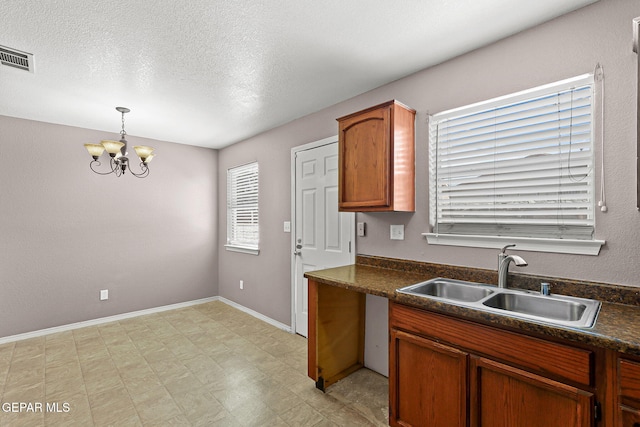 14310 Pacific Point Dr, El Paso, TX 79938 - kitchen featuring a sink, dark countertops, a chandelier, light flooring, and decorative light fixtures