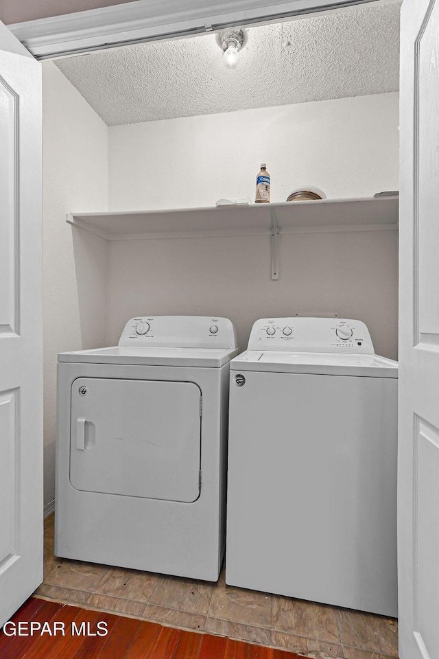 14310 Pacific Point Dr, El Paso, TX 79938 - washroom with washing machine and dryer, a textured ceiling, and wood finished floors