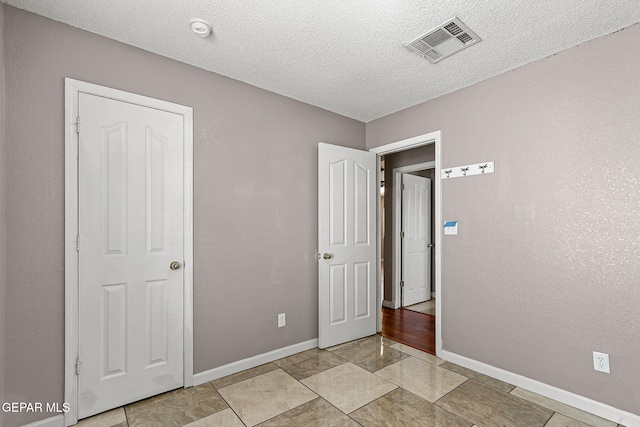14310 Pacific Point Dr, El Paso, TX 79938 - unfurnished bedroom with baseboards, a textured ceiling, and light tile patterned floors