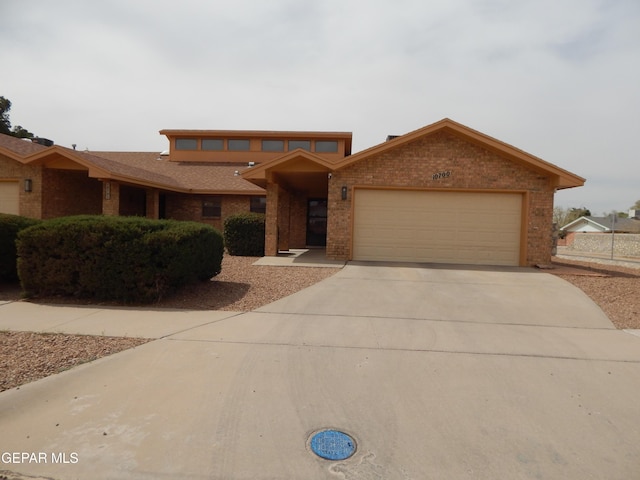 view of front of home with brick siding, concrete driveway, and a garage