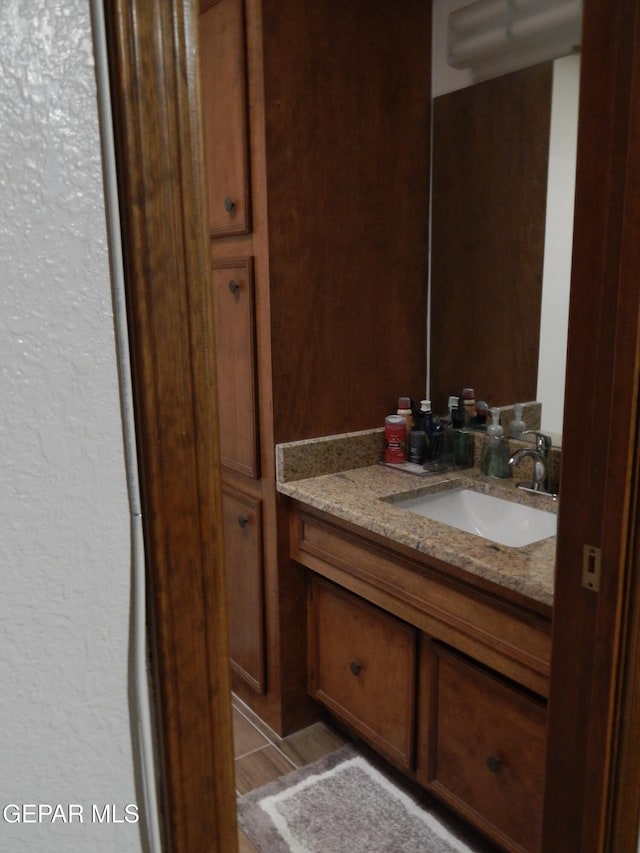 bathroom featuring a textured wall, tile patterned flooring, and vanity