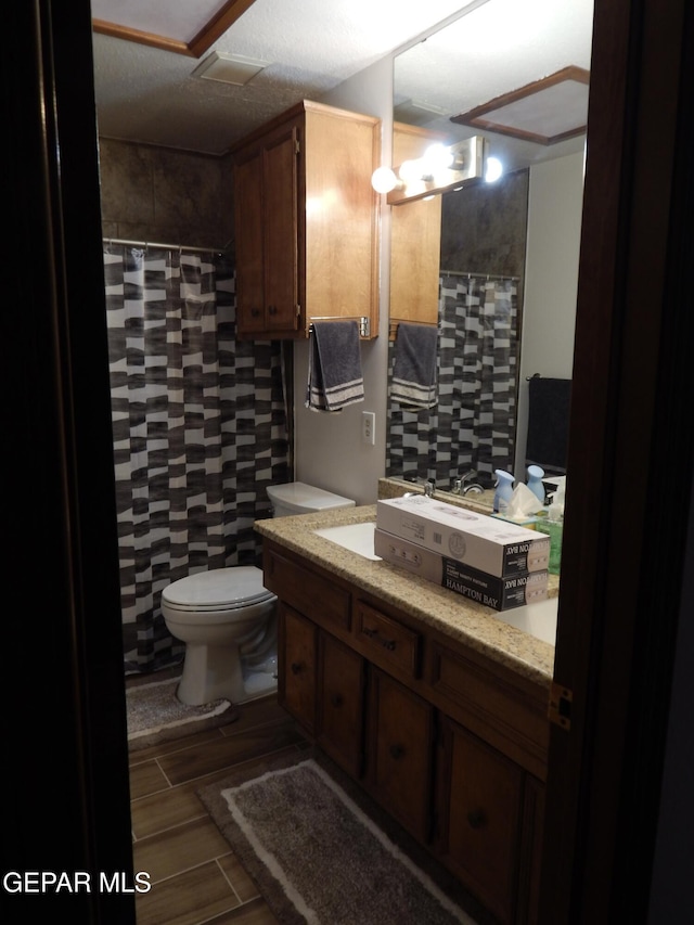 full bath with a shower with curtain, vanity, and toilet