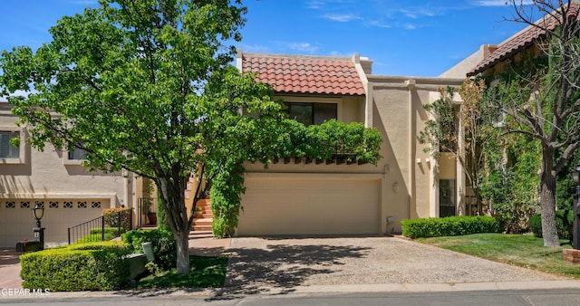 view of front of property with stairway, a tiled roof, stucco siding, driveway, and a garage