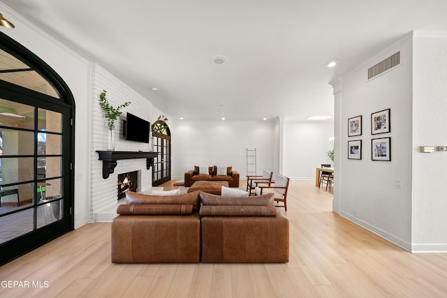 living room with recessed lighting, light wood finished floors, visible vents, baseboards, and a brick fireplace
