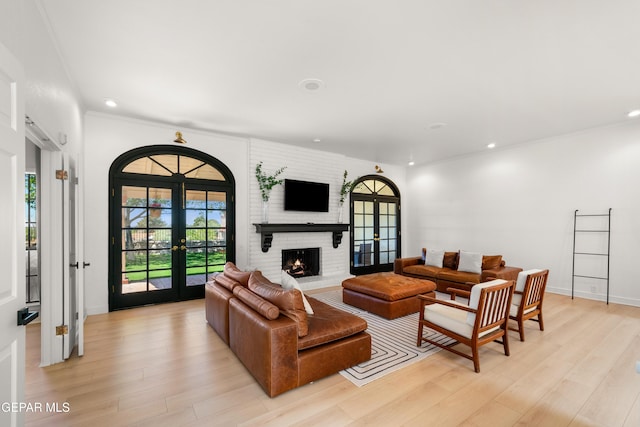 living area with recessed lighting, light wood finished floors, and french doors